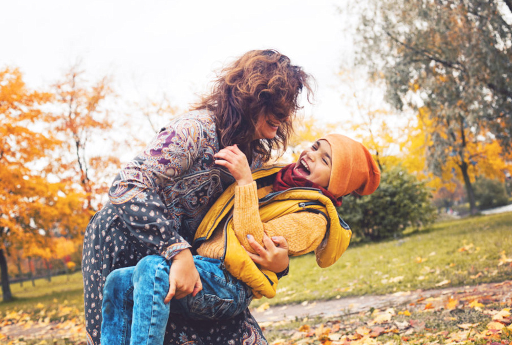 Family having fun outdoors. Mum and son together. Mother and child boy hugging in autumn park. 